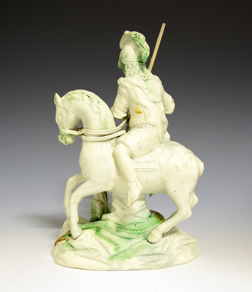 St. Georg til hest dreper dragen. Hvitglasert fajanse med håndmalte detaljer i grønt og gult.