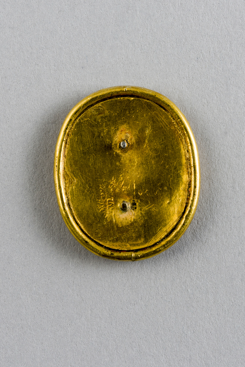 Del av pyntenål eller medaljong. Formet ovalt med fotoportrett av Jens Fabricius innrammet bak glass.