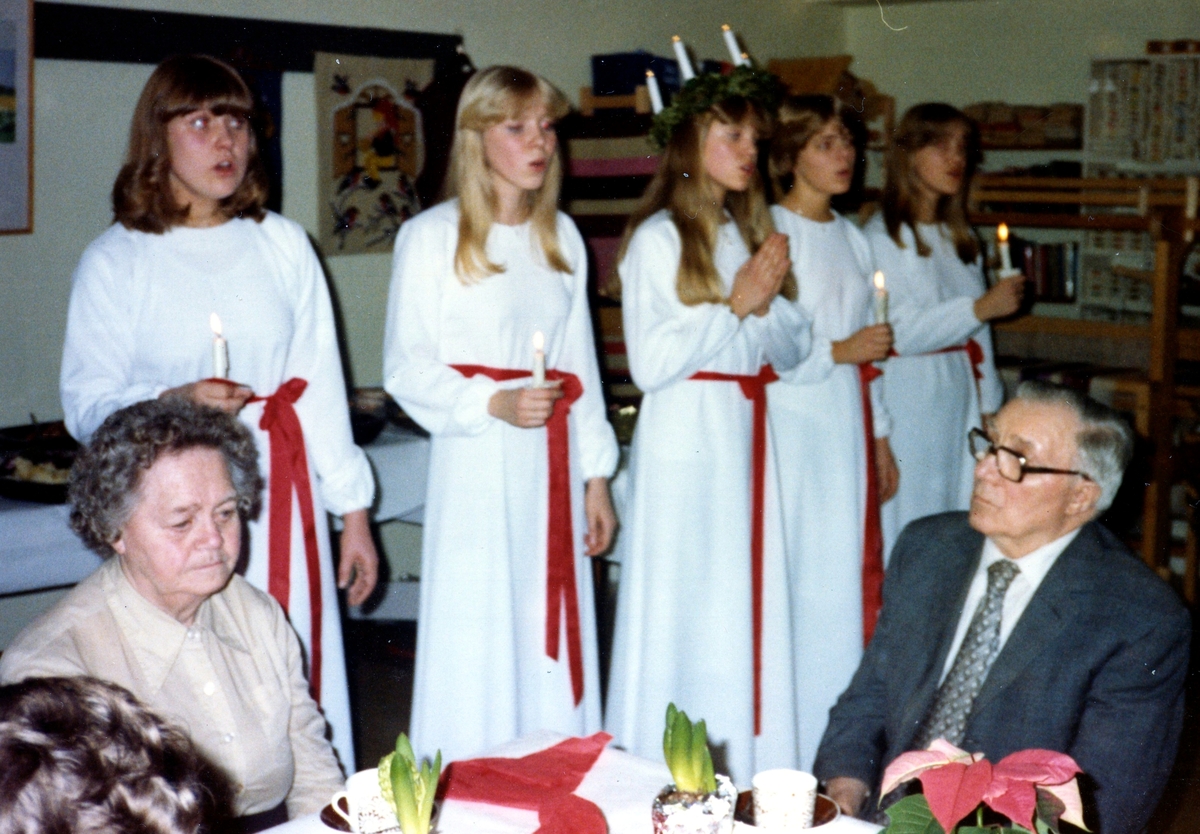Luciatåg i Brattåsgårdens hobbylokal på Vommedalsvägen, troligtvis 1980. Från vänster: Marlene Berzins, Annika Rydenfors, Elisabeth Andersson (Lucia), Cathrine Eneroth och Anna Gustavsson.