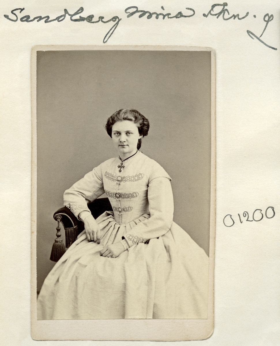 Porträtt av fröken ”Mina” Sofia Wilhelmina Sandberg. Född 1846 i Linköping som dotter till auktionsvaktmästare Per Gustaf Sandberg och Anna Helena Wigholm. Förblev ogift och levde med sin mor fram till sin död i sviterna av tuberkulos den 6 november 1887.