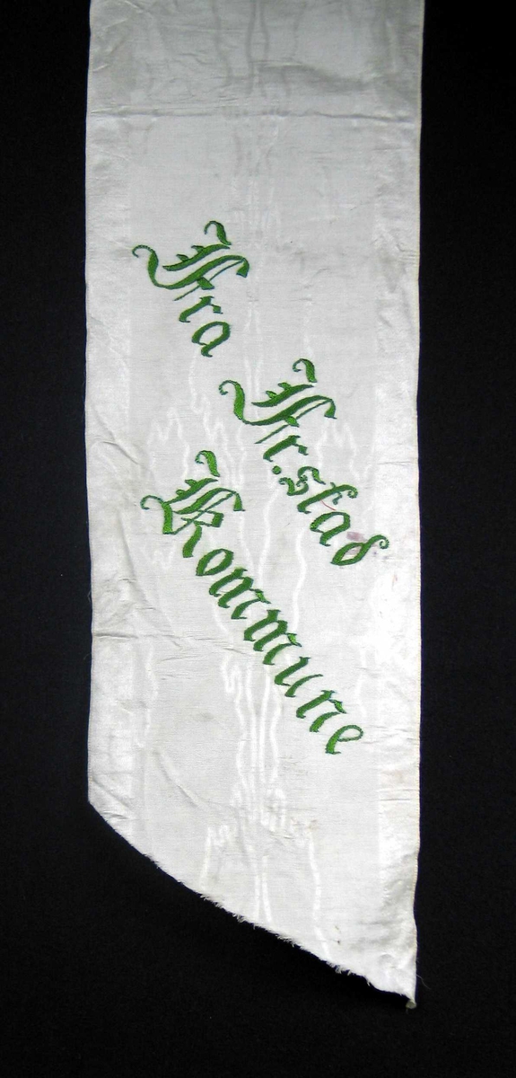 Begravelsessløyfe i hvit silke med grønn brodert tekst.