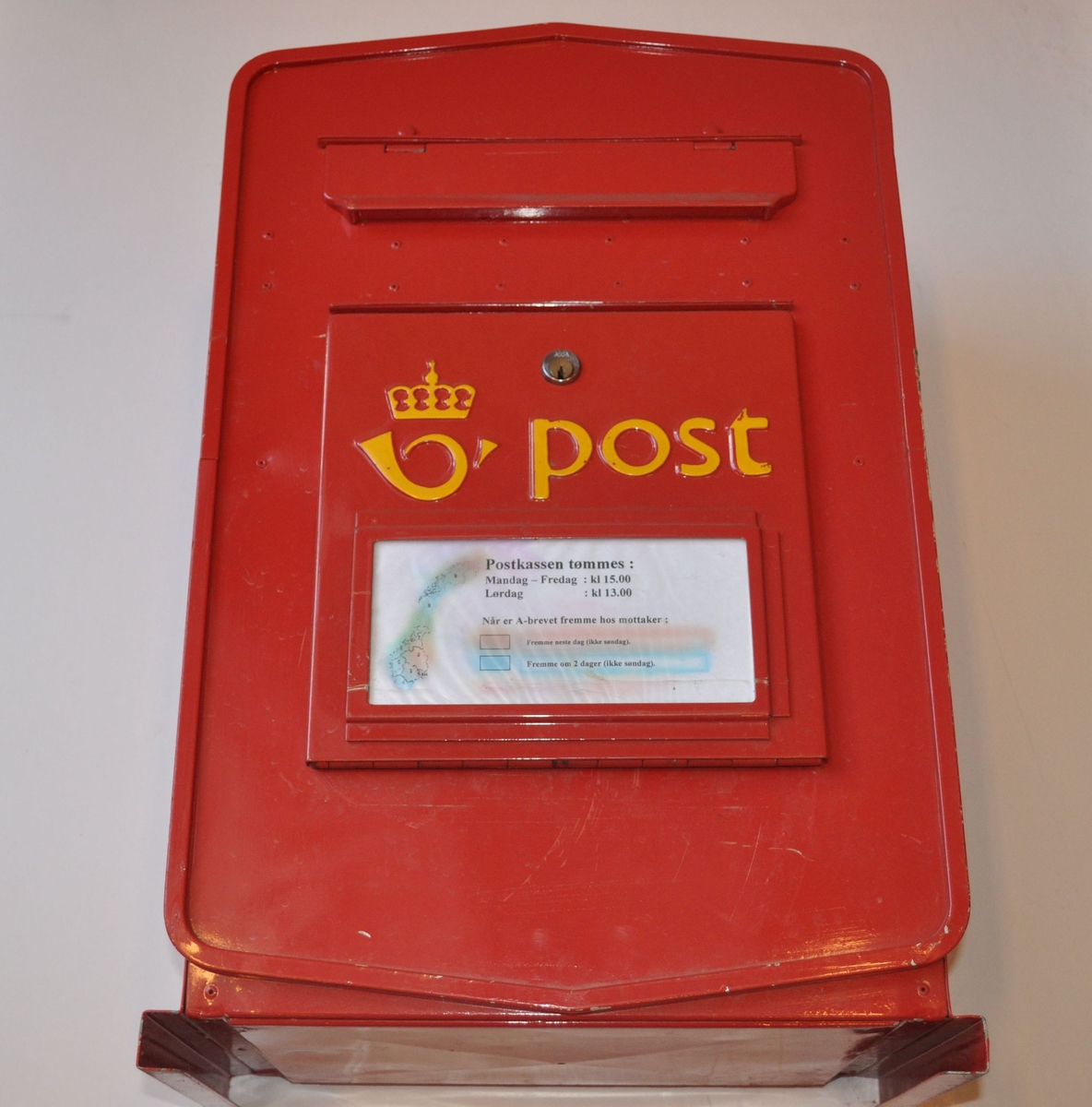 Rød postkasse med plakat.