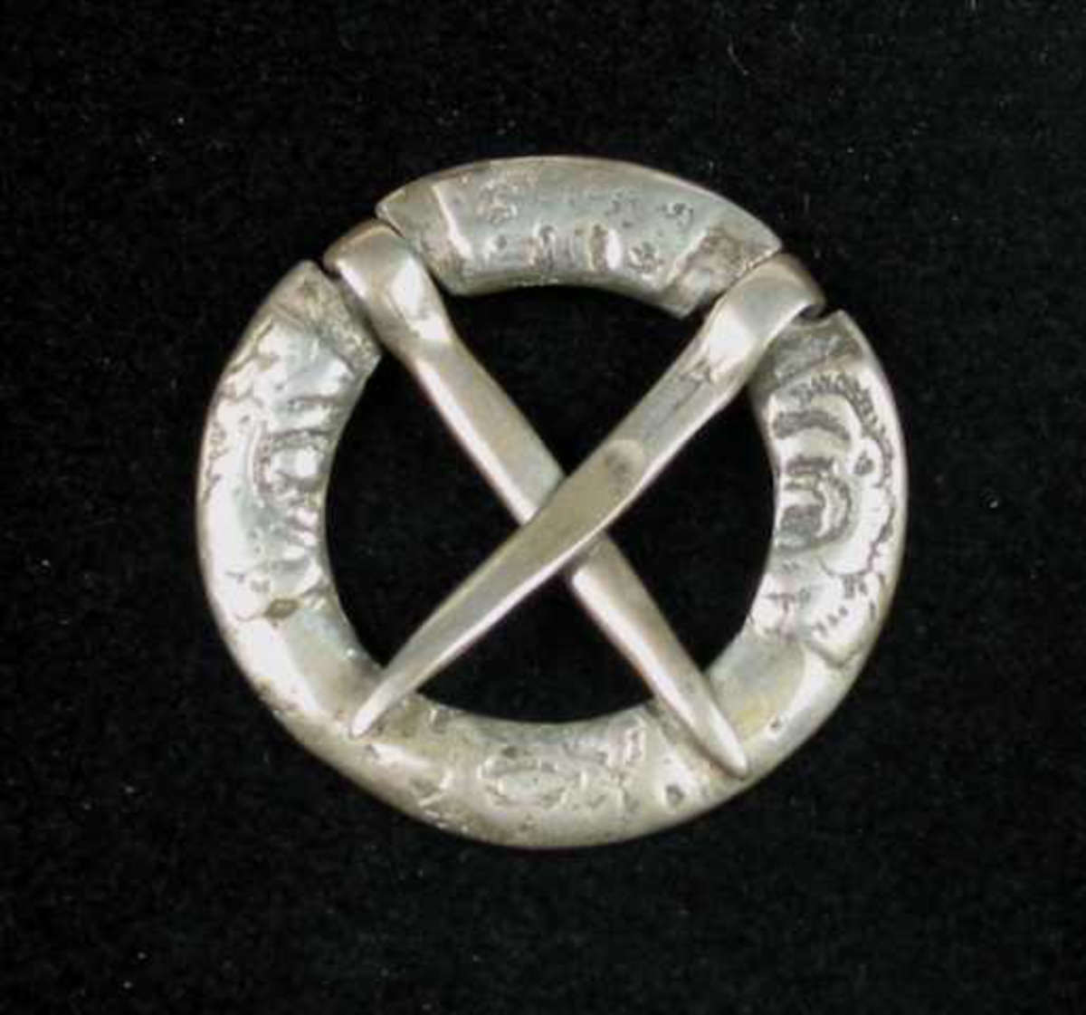 Lita bursprette av sølv. Den har to løse torner stilt i kors. Ringen er delt i fire felter, men dekoren er utydelig på grunn av slitasje. Det kan minne om et rosemotiv.