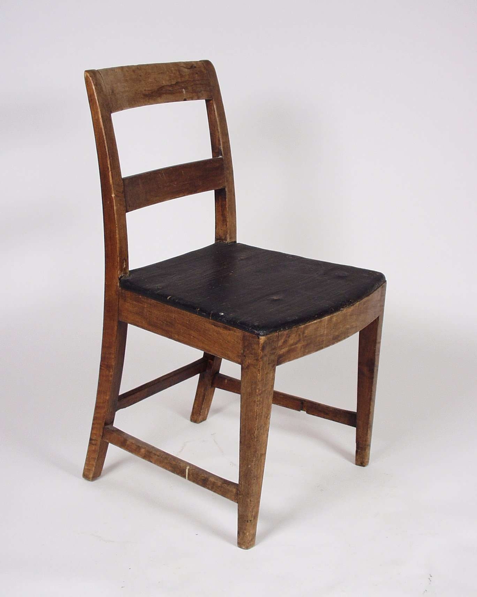 Stolen er i bjørk med sete av furu. Sete er svartmalt, mens resten er brunmalt. Midtsprossen mangler på den ene stolen.