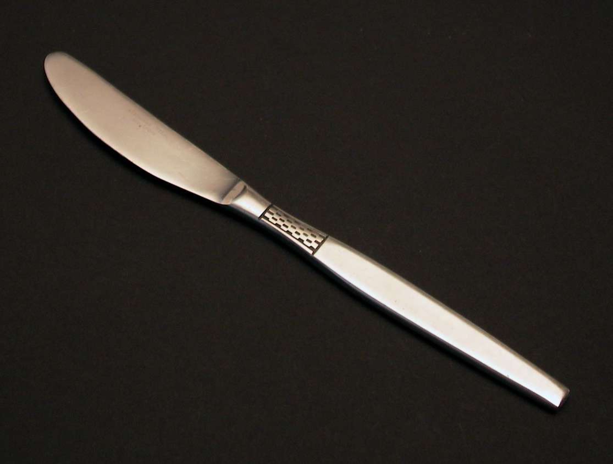 Seks kniver i rustfritt stål med geometrisk dekor på skaftet.