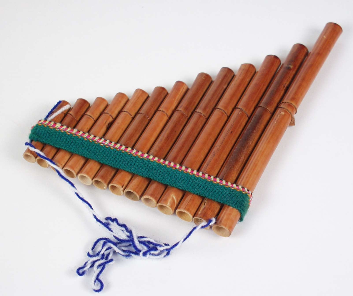 Fløyte satt sammen av bambusrør i ulik lengde.
Den er dekorert med et mangefarget bånd øverst.
