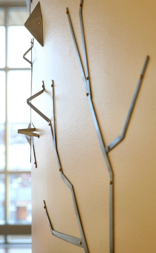 Ole Olsen Ansgar har laget en installasjon med utgangspunkt i det grafiske uttrykket bjørkeris lager mot snøen. De utsatte og værbitte bjørkene har sin egen rytmiske poesi, og lager uttrykksfulle, svarte streker i landskapet. På samme tid tilbyr de beskyttelse mot vær og vind. Veggskulpturen er laget ved hjelp av formelementer i rustfritt stål og stål.