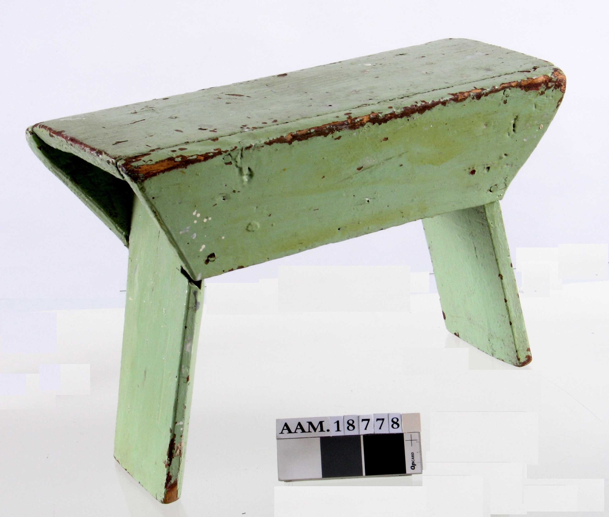 Krakk,  fra siste halvdel 1800-årene.   
Furu,   malt lys grønn. Under er den malt rødbrun.  
Smal, ustø krakk,   laget av grove bord.  To skråttstilte sidebord, to brede, innoverskrånede sargbord.  Tilstand: grønnmalingen avflekket til dels.
