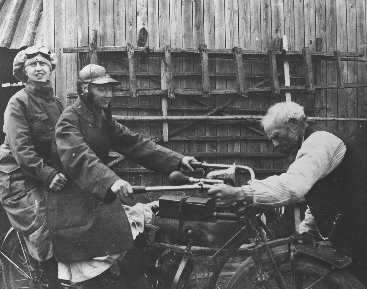 2 damer på motorsykkel (Indian 1916). 1 mann holder i styret