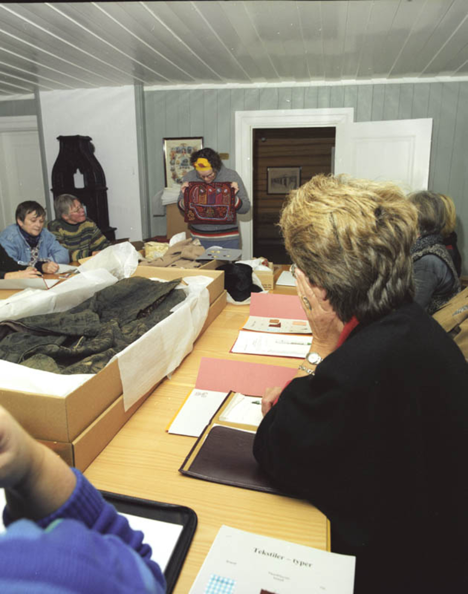 Kursleder Tanja Reed viser eksempler på Akershus fylkesmuseums kurs om bevaring av tekstiler.