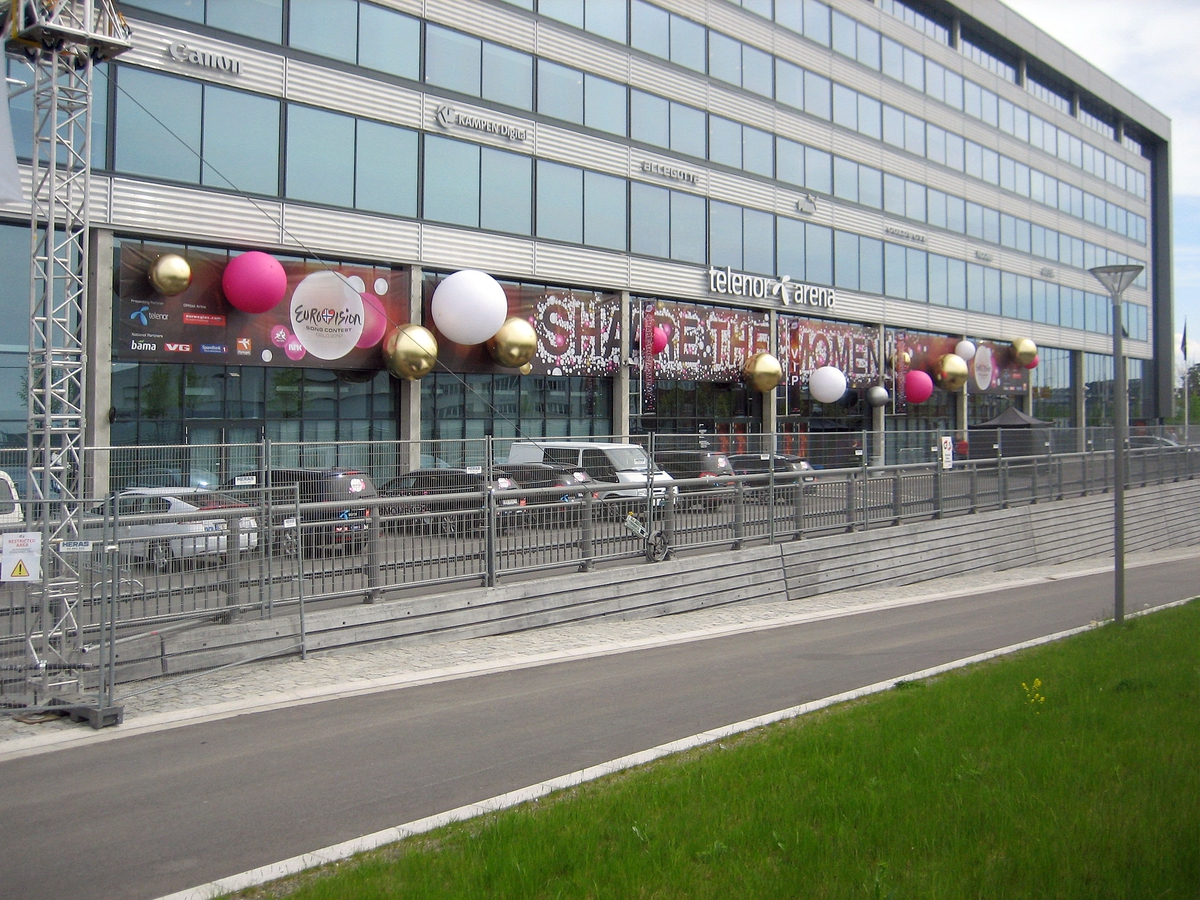 Eurovision Song Contest 2010 - Melodi Grand Prix
Fornebu - Telenor Arena. Den nederste delen av fasaden er prydet med banner med slagord, samt kuler i fargene rosa, hvitt, gull og sølv.