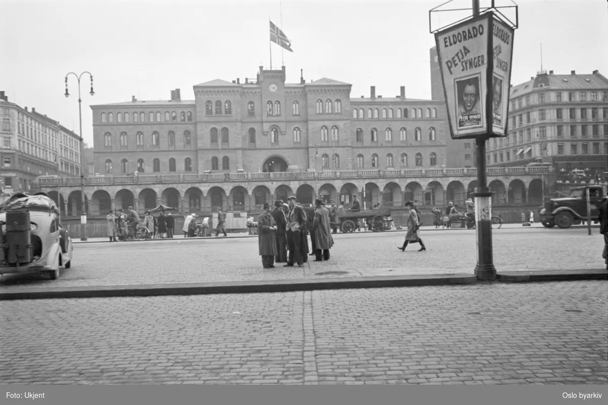 Nytorvet (Youngstorget fra 1951) med basarene og Møllergata 19, Hovedbrannstasjonen, i bakgrunnen. Folkeliv, hest og kjerre på torget. Reklame for sangeren "Petja" på Eldorado.