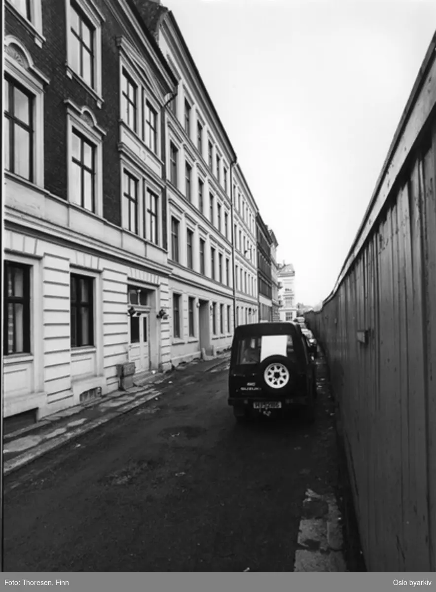 Renovert bygård. Opp-pusset fasade, Ruseløkkveien 59B (i midten). Avskjermet plankegjerde mot gata.
