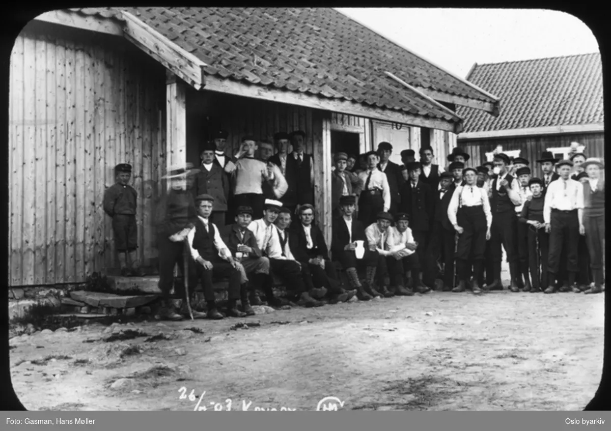 En gruppe menn og ungdommer som poserer for fotografen, 26. juli 1903. Krysby gård i Lommedalen?