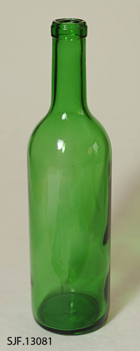 Flasken er av grønt glass, og har en sylindrisk form. Den har flat bunn. 
