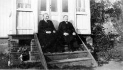 2 eldre damer sitter i trapp. Ukjent sted.