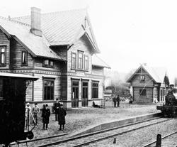 Eksteriør, Brumunddal jernbanestasjon, godshus, 7 menn på pe