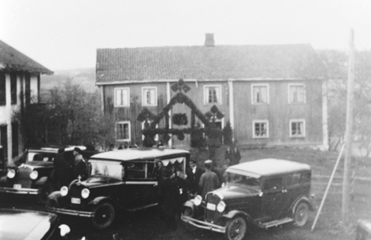 Bjørnerud, Furnes. Begravelse etter Anne Bjørnerud (1856-1930), parkerte biler, portal av granbar.