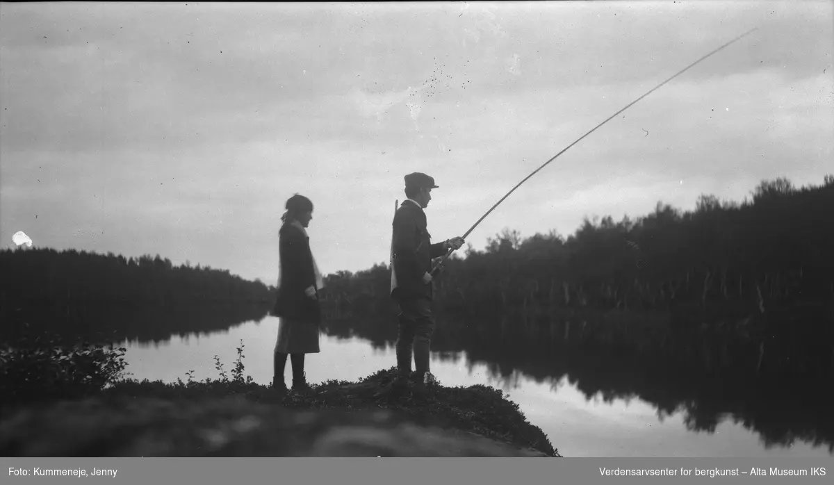 kvinne og mann på bær- og fisketur. Skog og Smavannet i bakgrunn. 1921