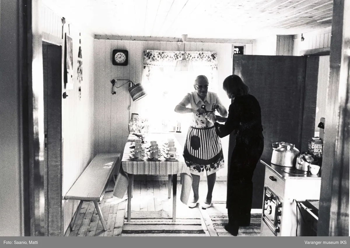 Ida Tuomainen på kjøkkenet i Tuomainengården med en annen dame. 1977