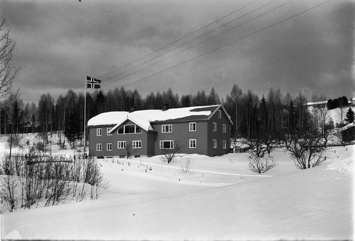 Eksteriør, vinter. Ukjent hus som flagger med det norske flagget. 