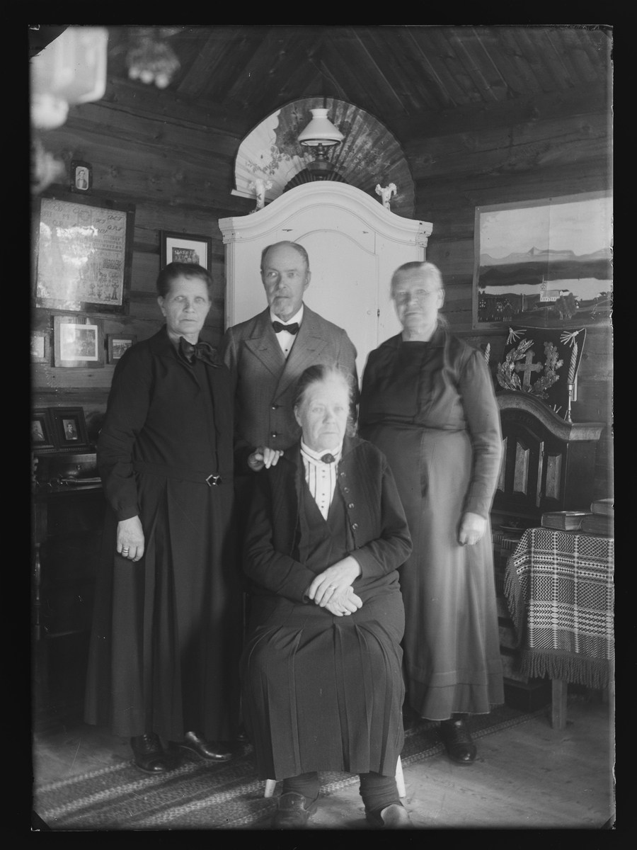 Portrett av tre kvinner og en mann i stueinteriør