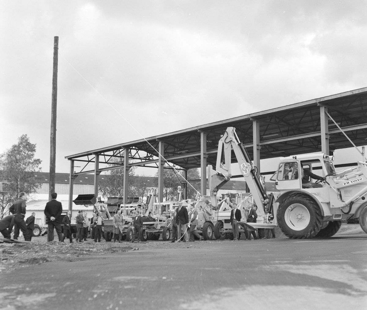 A/S Hymas, Hymas Gravemaskin. (Foto for Telegrafverket?) Demonstrasjon av BM Volvo, traktorgravemaskin. 17. 08. 1967. Brumunddal. Oppssetting av telefonstolpe. 