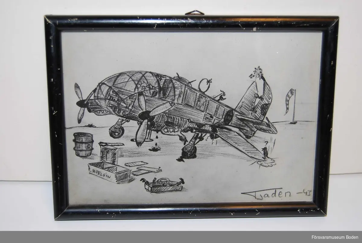Inramat fotografi av teckning, avsedd att hängas på vägg. Skämtteckning som visar på flygplanets ursprungliga konstruktionsbrister.