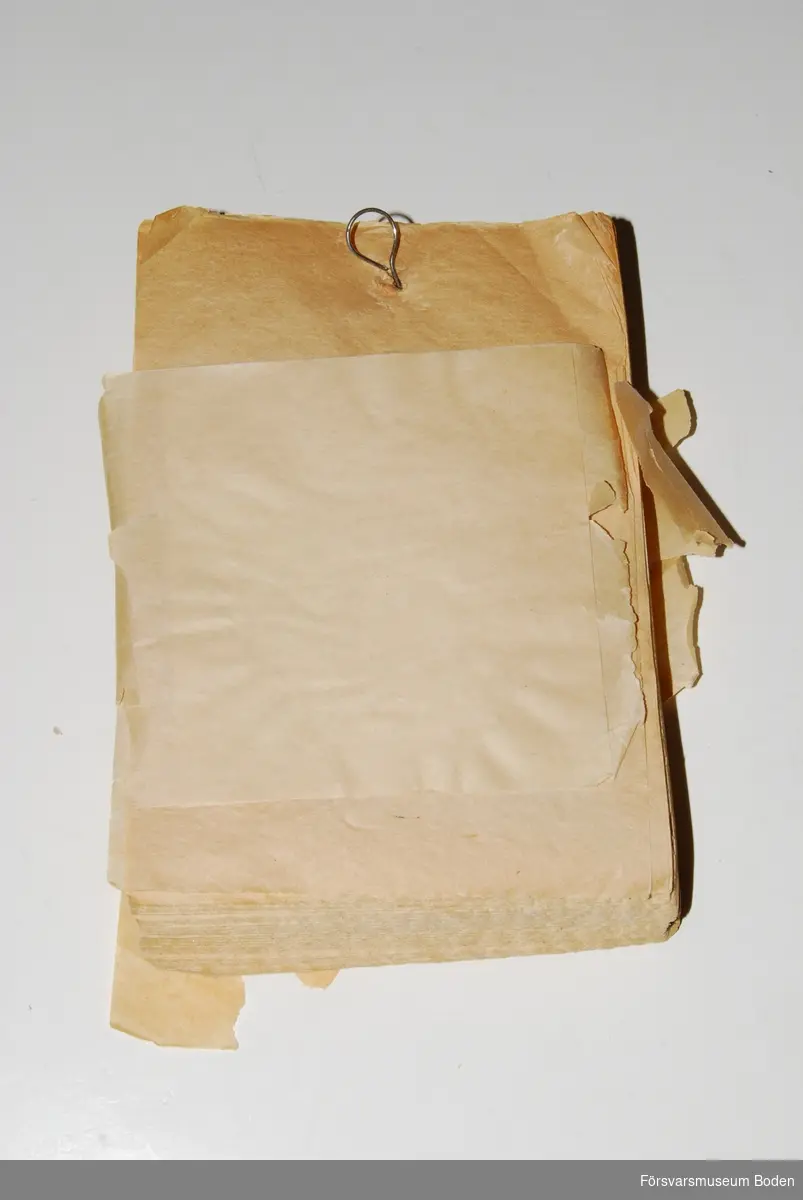 Bunt med 300 ark 11 x 16 cm, ursprungligen ombunden med pappersremsa men denna har skadats. Upphängningsögla på baksidan.