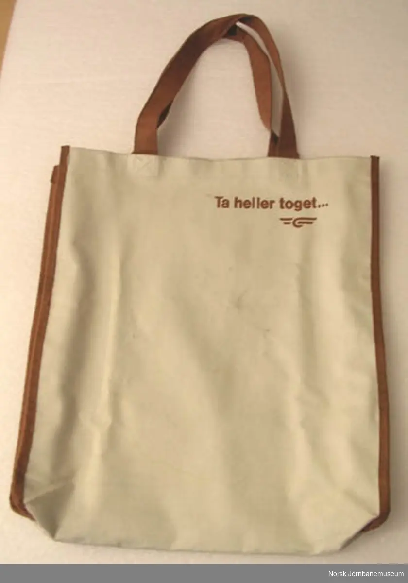Bærepose med NSBs logo og teksten "Ta heller toget"