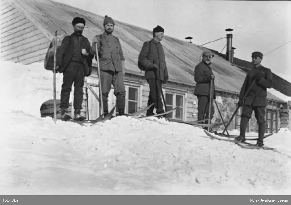 Bergensbanens anlegg; fem menn på ski foran ingeniørboligen på Hallingskeid