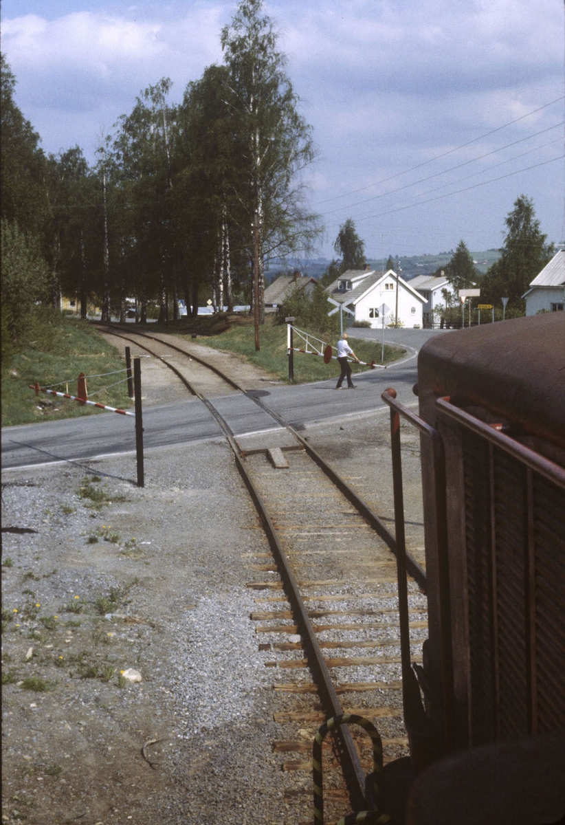 Godstog på Skreiabanen, utsikt fra lokomotivet. Manuell betjening av bom på planovergang