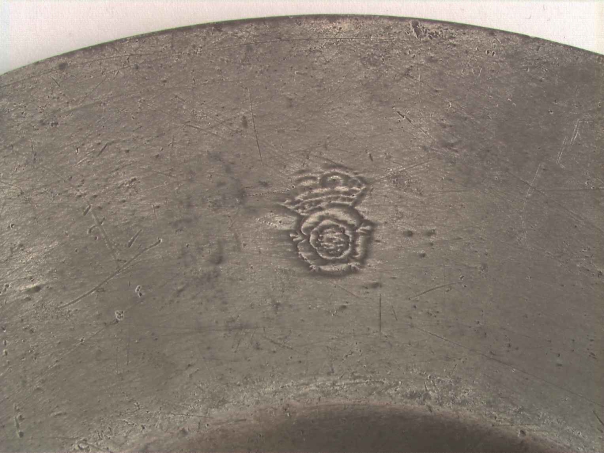 Motiv på de tre tinntallerknene viser en hodeskalle og en blomsterbukett over to ridderhjelmer og våpenskjold