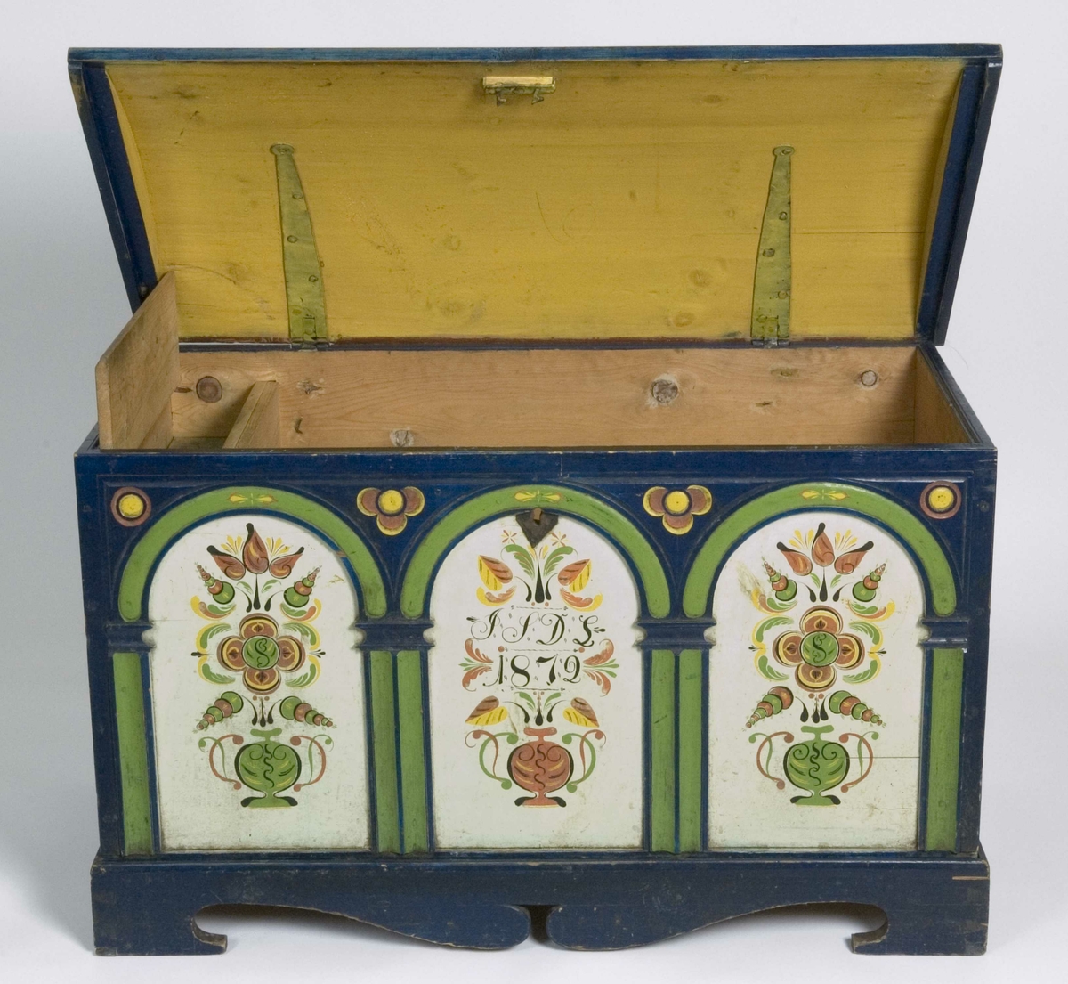 Kiste med buet lokk og fotstykke. Lokket er rosemalt og forsiden har tre buer med rosemalte fyllinger.