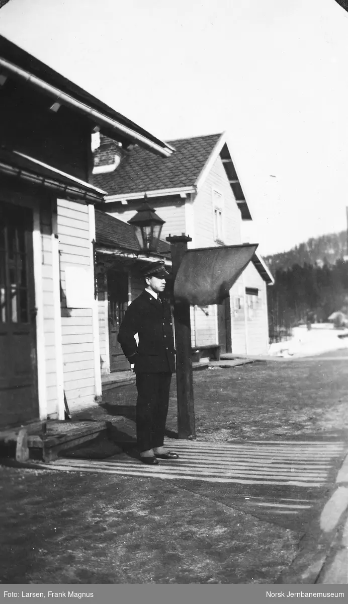 Telegrafist Frank M. Larsen på Sandermosen stasjon med oppsatt flagg