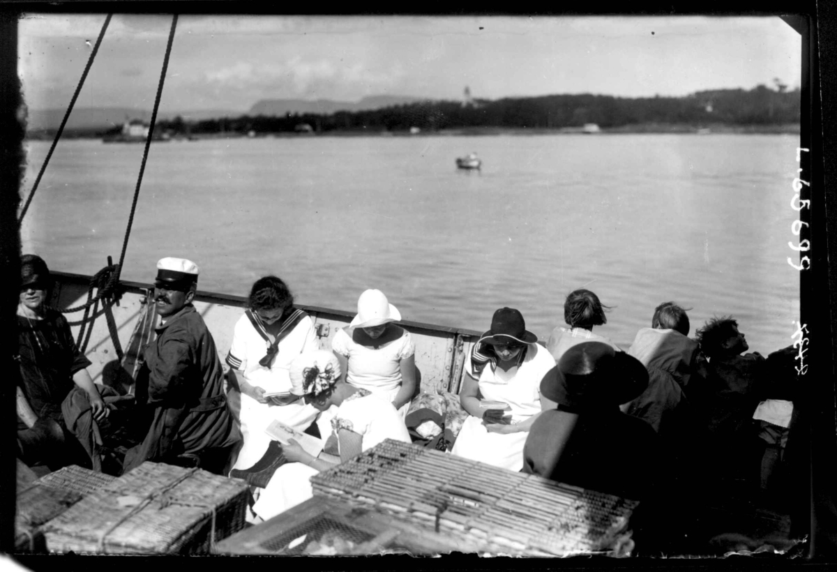 Oslo. Bilde av passasjerer ved relingen på en båt i Oslofjorden. Bygdøy i bakgrunnen.