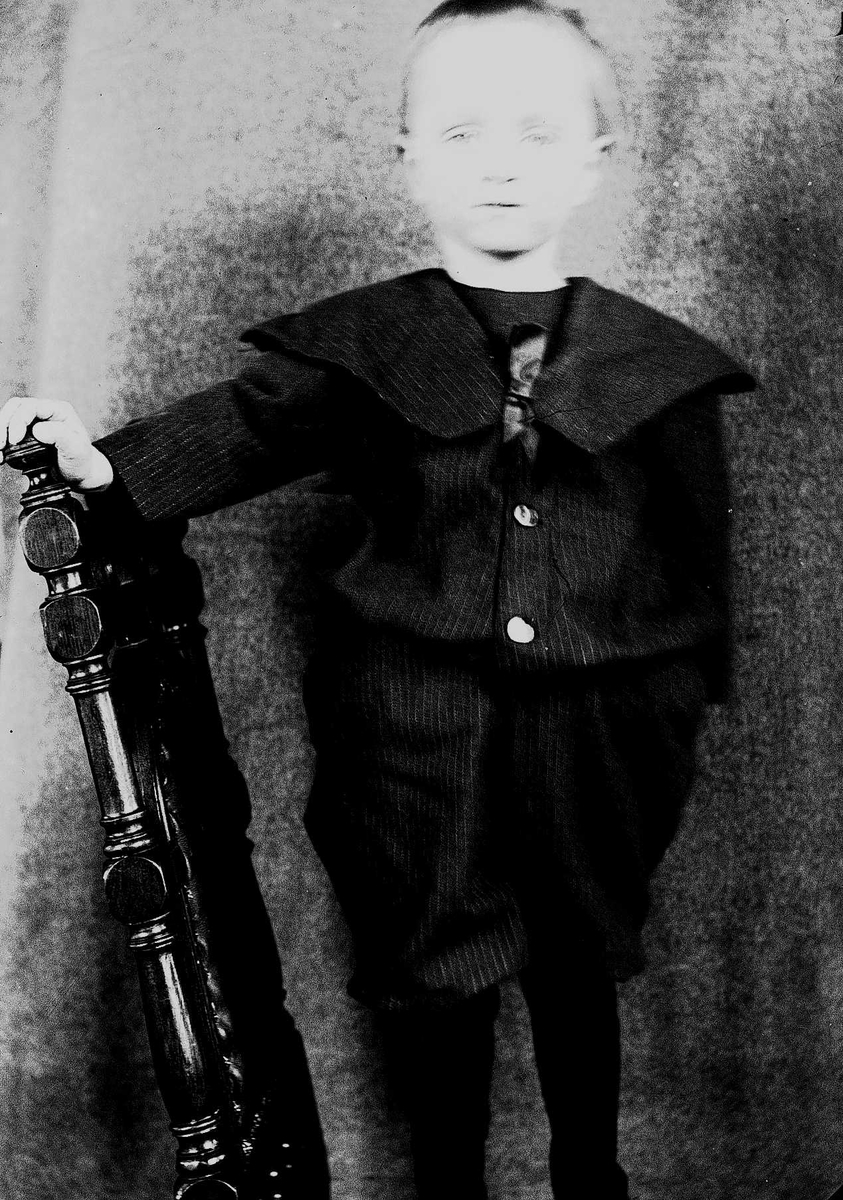 Portrett av gutt på en stol, Halvor Nicolai Q. Wiborg, Digerud, Frogn, Akershus, februar 1907.