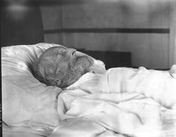 Gammel mann liggende i seng, ukjent sted. Dødsleie?