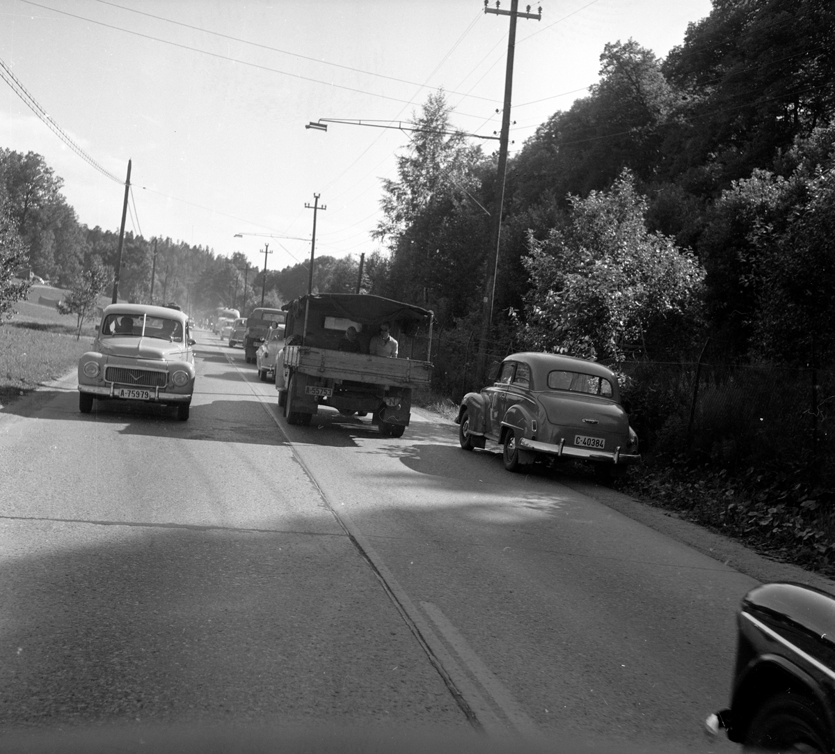 Biler på Riksvei 1. Fotografert 7. juli 1958. Til høyre: A-75979 en Volvo PV 444 1958. Karakteristisk med V i grillen og siste årsmodell med delt frontrute.