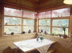 Et bord og to benker står i hjørne ved vinduer i et hus i Na