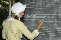 Levendegjøring på museum.Ferieskolen uke 31. Elev skriver p