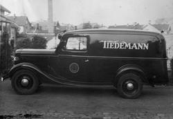 Bil av typen Ford V8 1936, med reklame for Tiedemann.