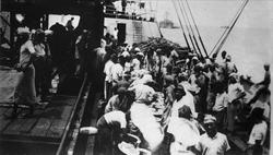 Avfotografering. Menneskemengde på kaia og i en båt. Mannfol