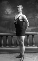 Portrett, bryter, med drakt og medaljer. Herbrand Lofthus. I