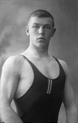 Portrett, mann i brytetrøye viser muskler. Bryter?