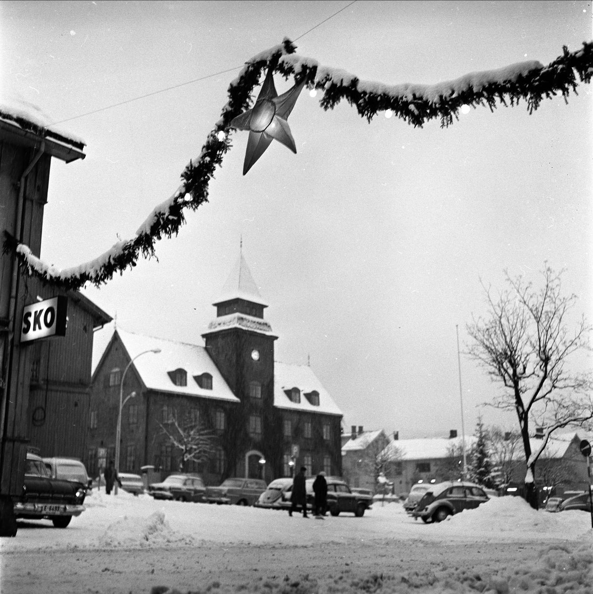 Lillehammer, Oppland, 03.01.1961. Torget med biler og julegater.