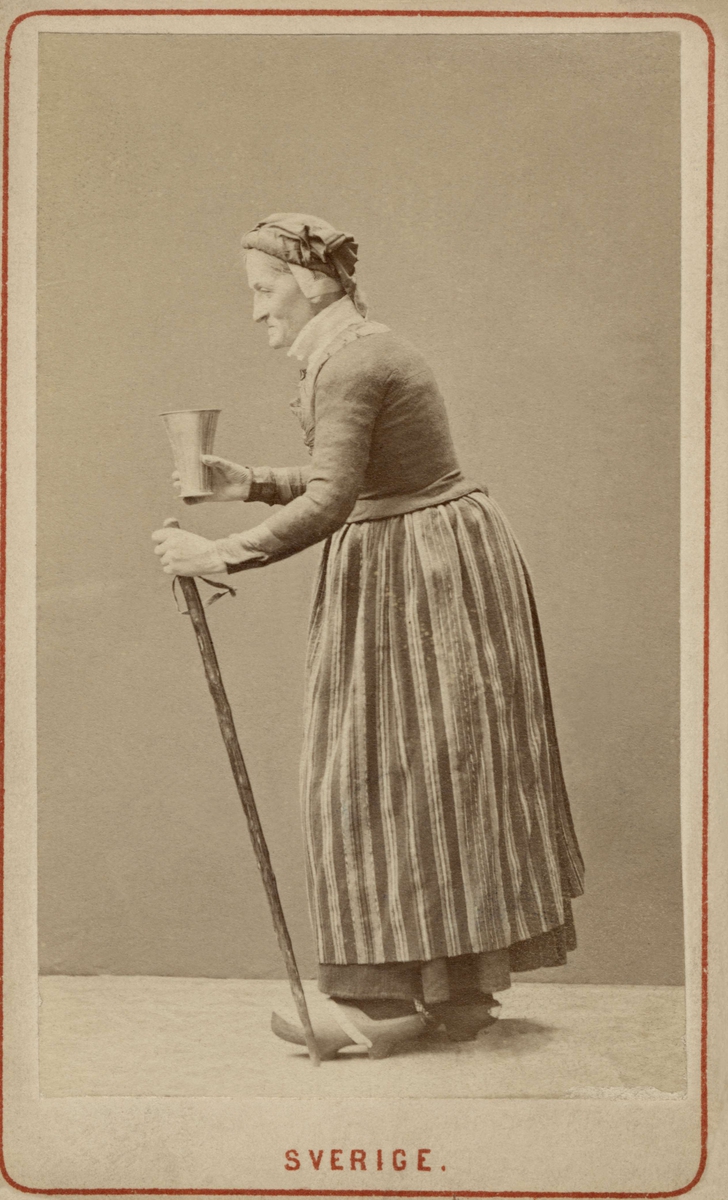 En äldre kvinna i profil, dräktdocka.