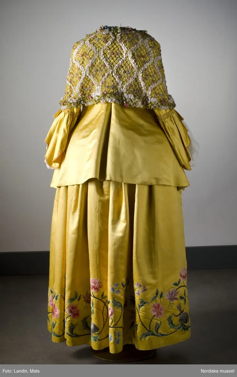 Dräkt av gul atlas med silkebroderier. 1700-talets mitt. Nordiska museet inv nr 171126.