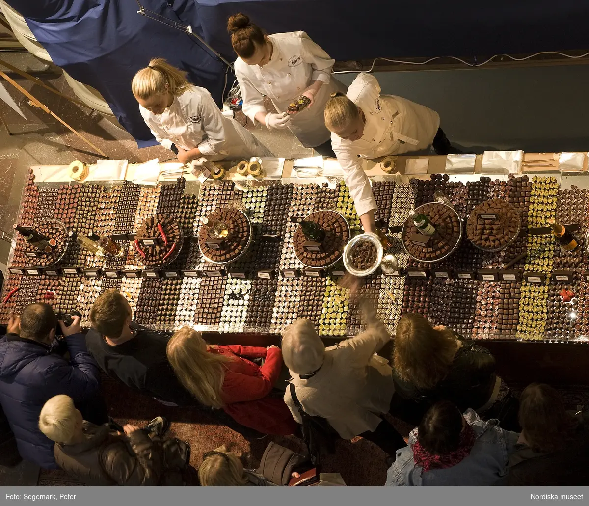 Dokumentation av Chokladfestivalen 15-17 oktober i Nordiska museets stora hall.

För nionde året i rad intog chokladtillverkare, leverantörer, chocolatierer och konditorier museets stora hall och visade upp och sålde det senaste inom kvalitetschoklad. Praliner, chokladkakor och bakverk presenterades av utställarna. Årets konditor - Roy Fares - utsågs under chokladfestivalen. Dessutom hölls en chokladskulpturtävling för sockerbagare där temat var ägget och besökarna fick rösta på sitt favoritbidrag. Här vann Team Dragons chokladskulptur  överlägset. ( se bild: NMA.0056762_29) Teamet, bestod av Alicia Dahl, Therese Vesterholm, Linn Danielsson, Kim Westerling & Anna-Kitty Jonsson. Alla kommer från Yrkeshögskolan för bagare och konditorer i Kristiandstad. Tre team från skolan deltog i skulpturtävlingen. 
