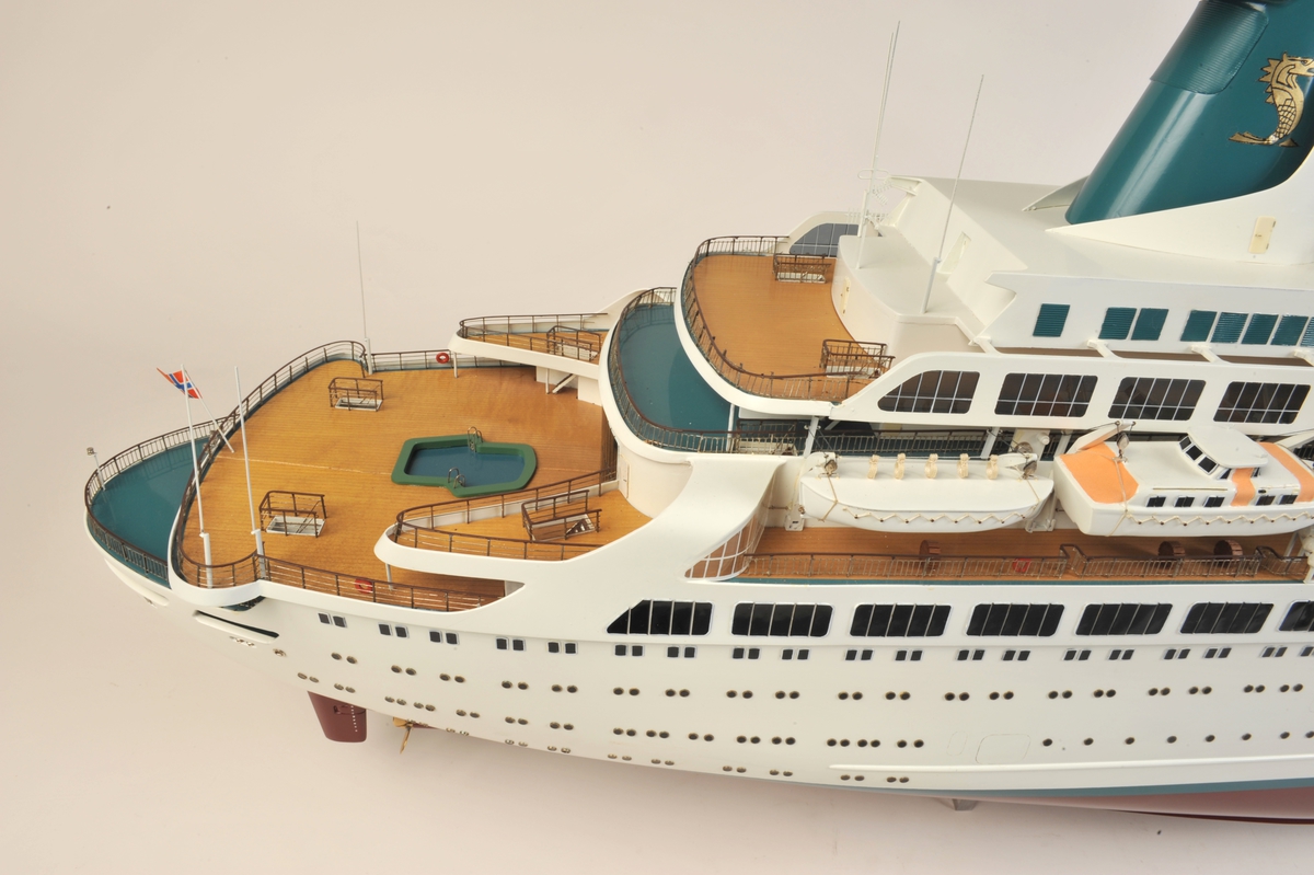 Hvitt passasjerskip med 6 livbåter på hver side, 2 av typen motorlaunche, rødt undervannsskrog, tynn grønn linje over vannlinjen, bvitt skrog, grønn skorstein med gyllen havhest.